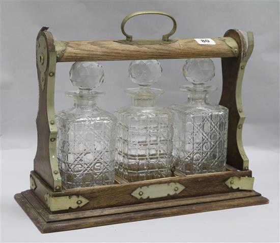 An oak and plated framed three bottle tantalus